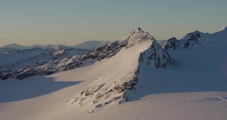 A slope in a snow covered mountain range in the evening