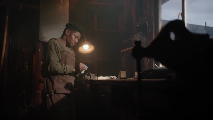 A man stands at a workbench while preparing to do some woodwork