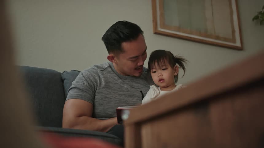 Father is holding his kid and they are laughing together