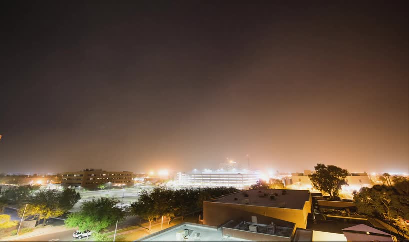 Dust storm flowing over a city at night