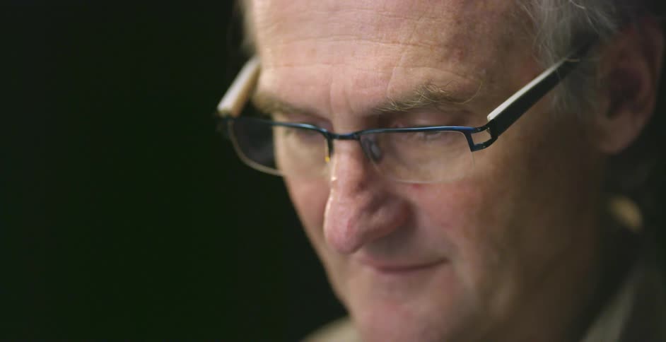 A man with glasses is looking down