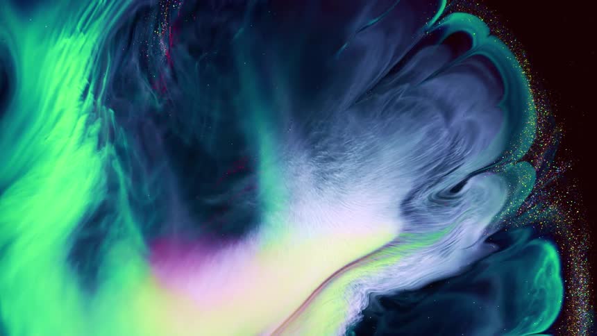 Bright vibrant colorful liquid ink expands over a black background