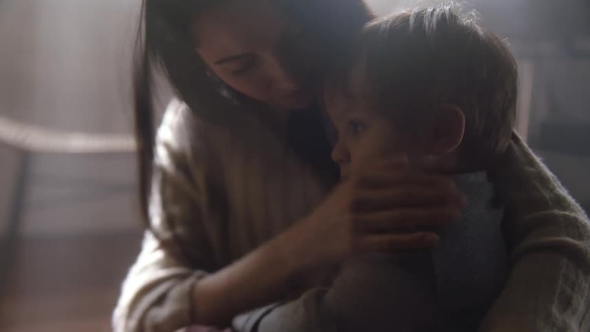 A mother holds her son close
