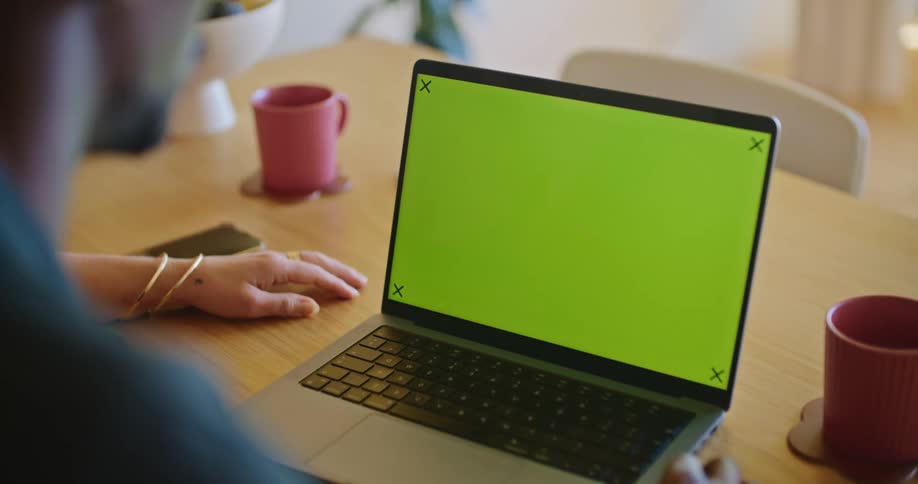 Man and woman sitting at desk look at laptop screen
