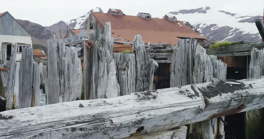 Broken wooden pillars next to a ramshackle warehouse