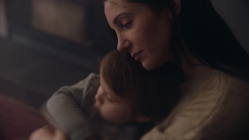 A mother is hugging her son