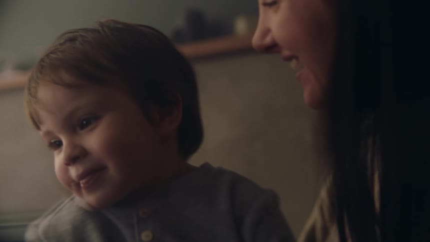 Mother holds young son close and smiles
