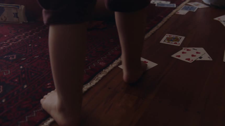 A child walks on the playing cards