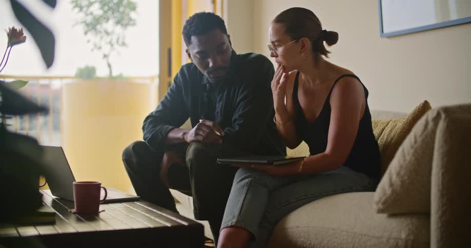 A man and woman talk while holding a tablet