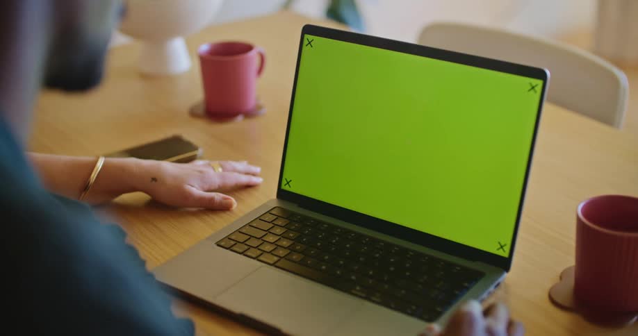 A laptop sitting on a table in front of a man who is sitting next to a woman