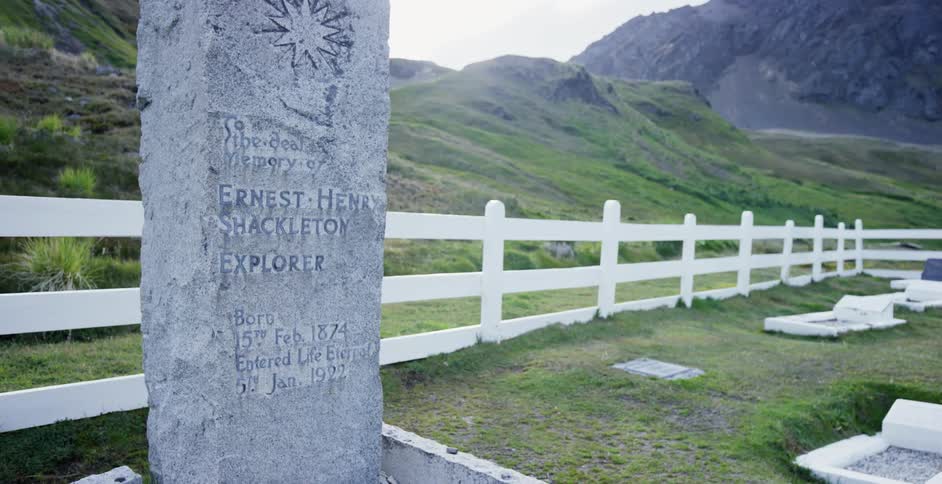 A tall headstone in a cemetery in a mountainous area