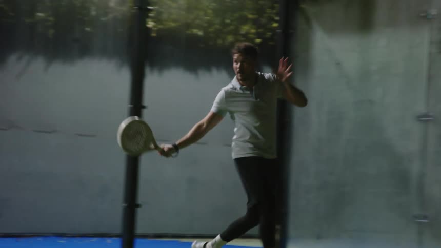 Young active man playing squash on an indoors court celebrates victory
