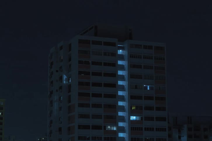 Time lapse of the night lights turning off in a tall building in the city