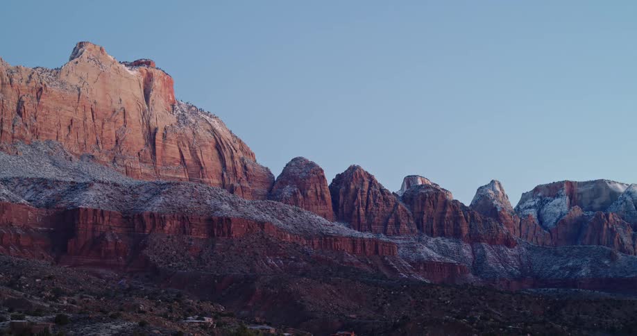 The sun shines upon red rock mountains near Zion National Park