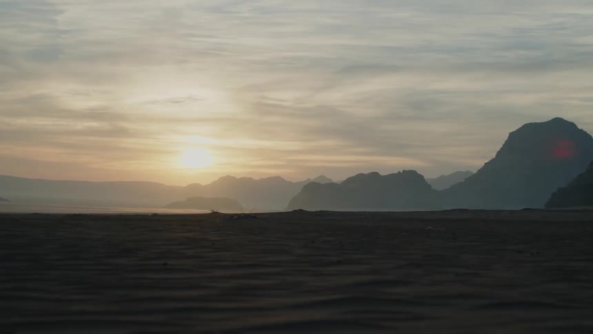 The sun is rising on the desert