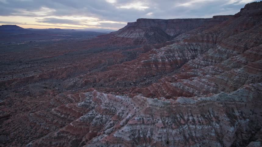 An aerial view of rocky red plateau cliffs, mesas and canyons