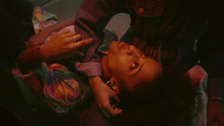 A man caresses his girlfriends face while she lies on his lap