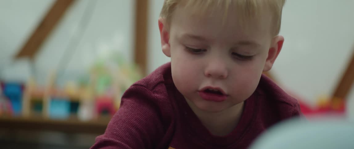 A young toddler is playing with toys inside of his room