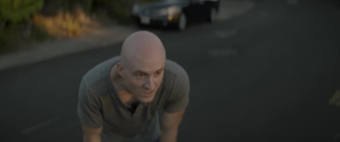 Man stands in street catching his breath
