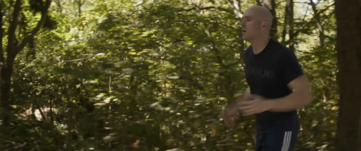 Man runs along woodsy path