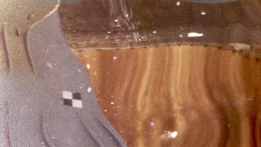 White chunks fall through liquid over warping background and dissolve as they float downward