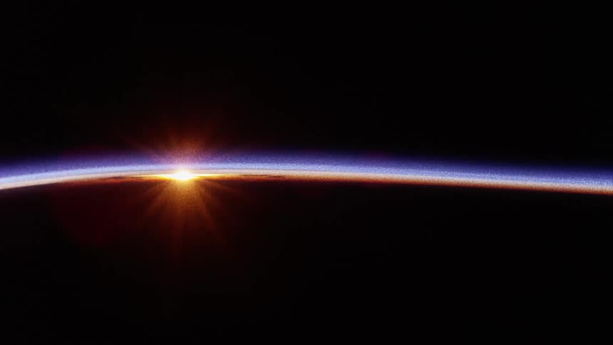 A black horizon with sunlight shining over the edge