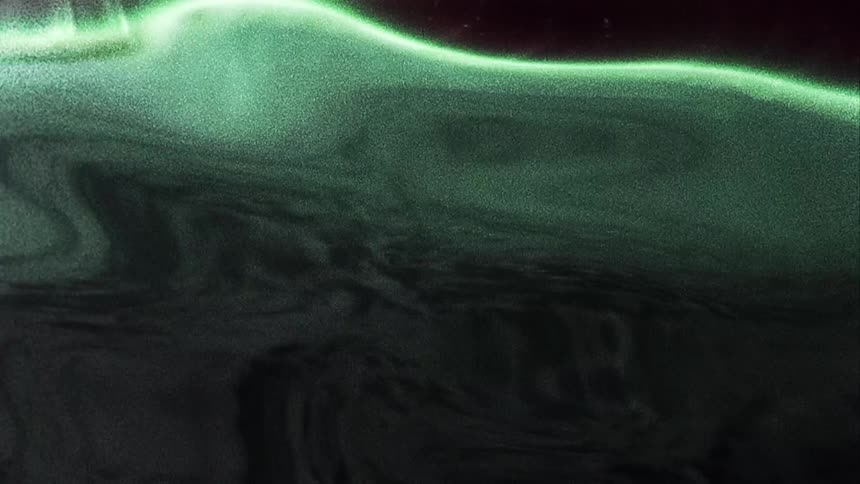 Abstract distorted footage of waves of bright green colours waving