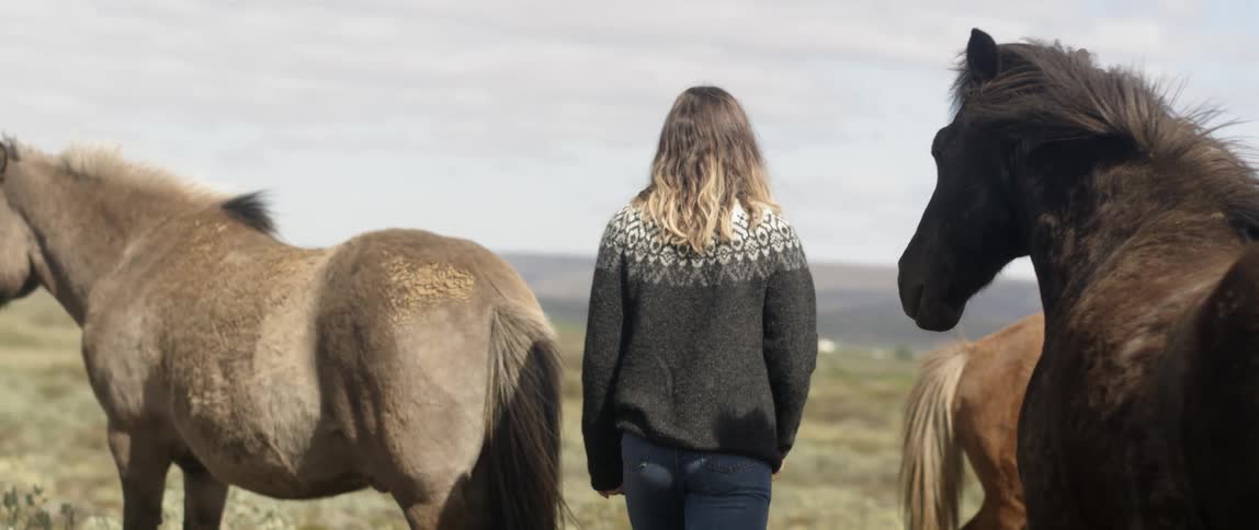A woman walks outside near horses