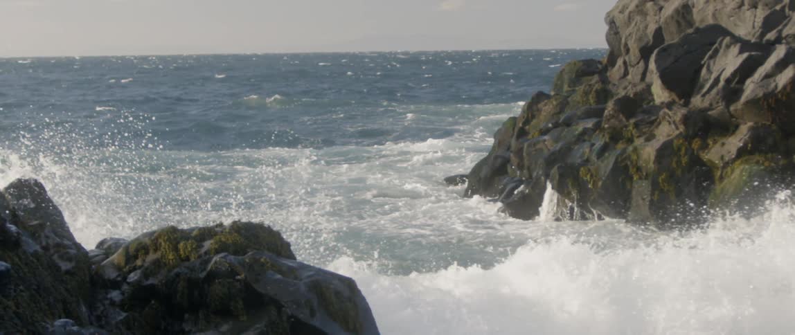 Ocean waves crash into rocks