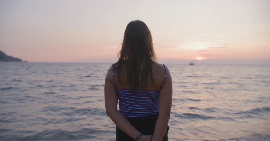 A woman watching the sunset at the ocean