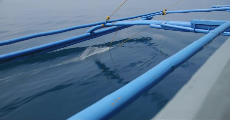 A boat floating over ocean water in the daytime
