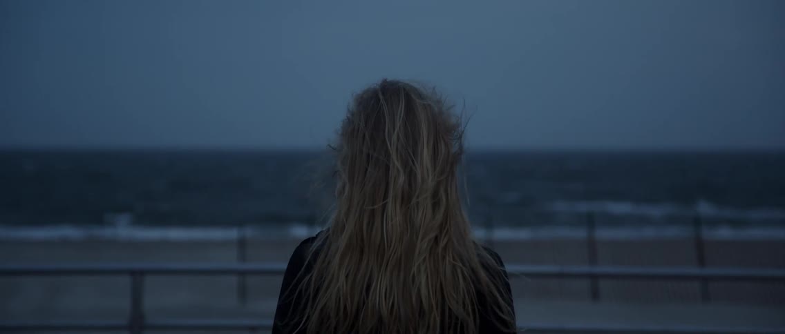 The wind blows on a woman at the beach