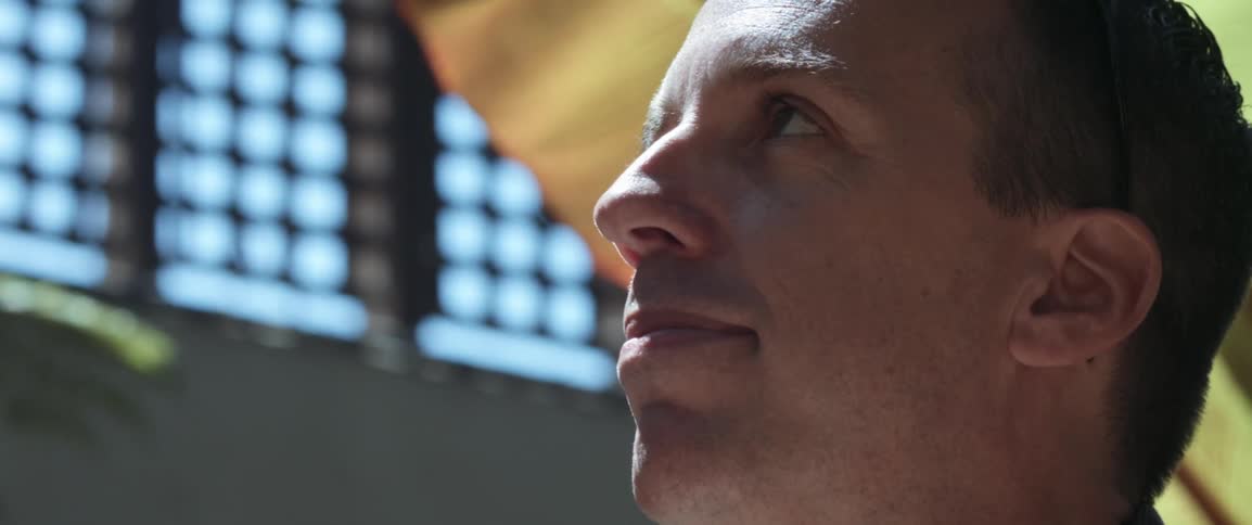 A white man looks upwards while indoors