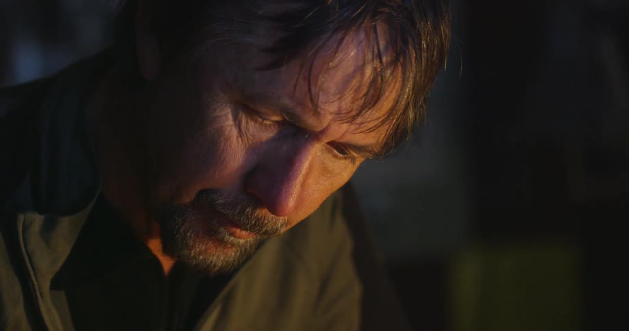 A man is looking down in a dark room