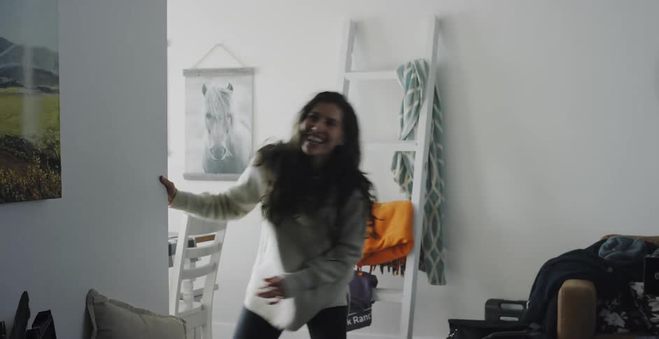 A woman is running across her room and playing