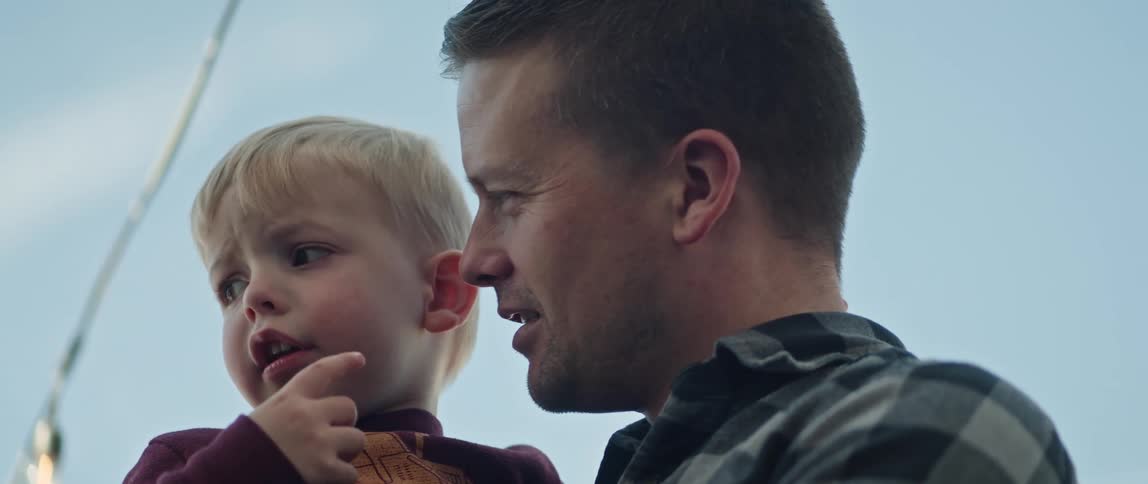 Father holds son and points out interesting things while talking to him