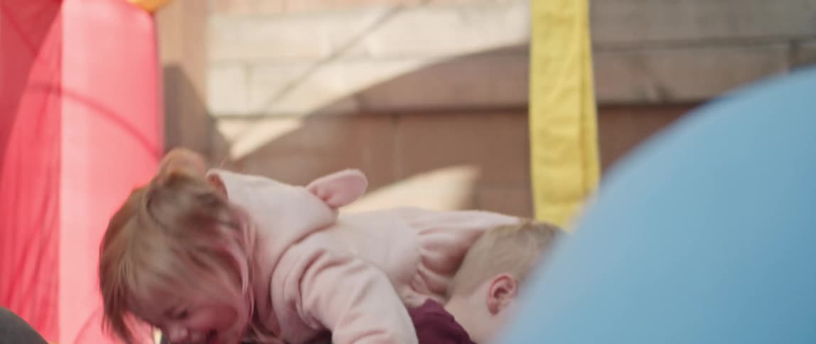 A woman plays with her children outside