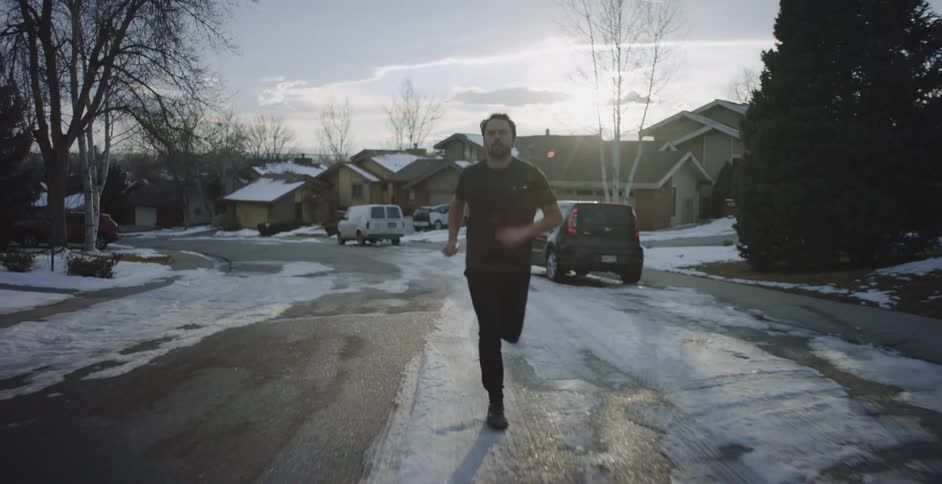 A man runs down a neighborhood street