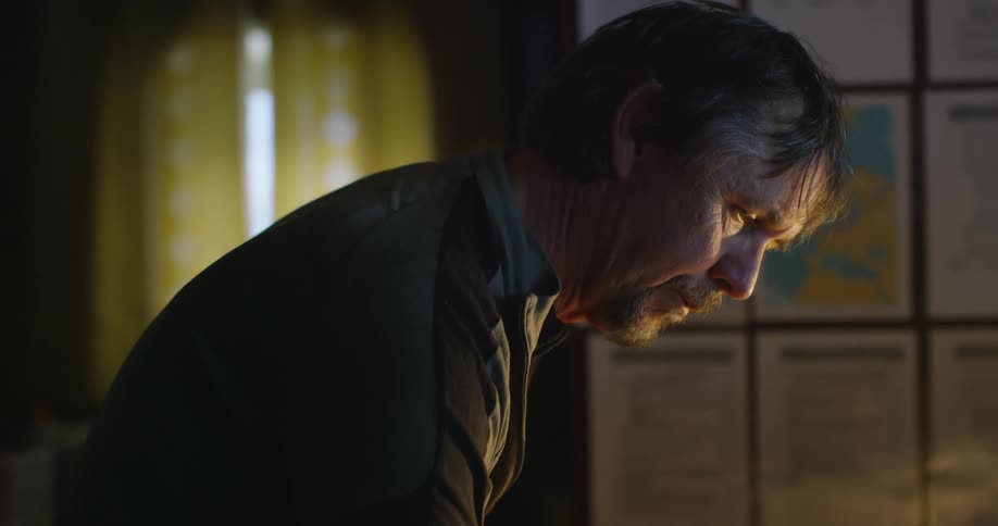 A man is looking down in a dark room