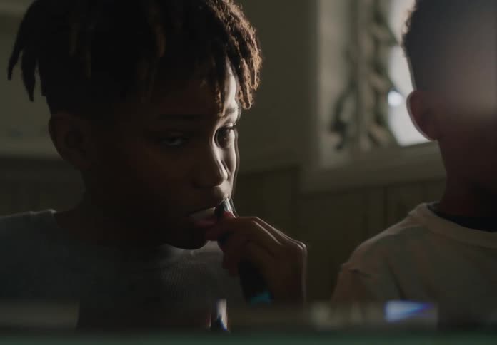 Two young boys brushing their teeths together in the bathroom at home