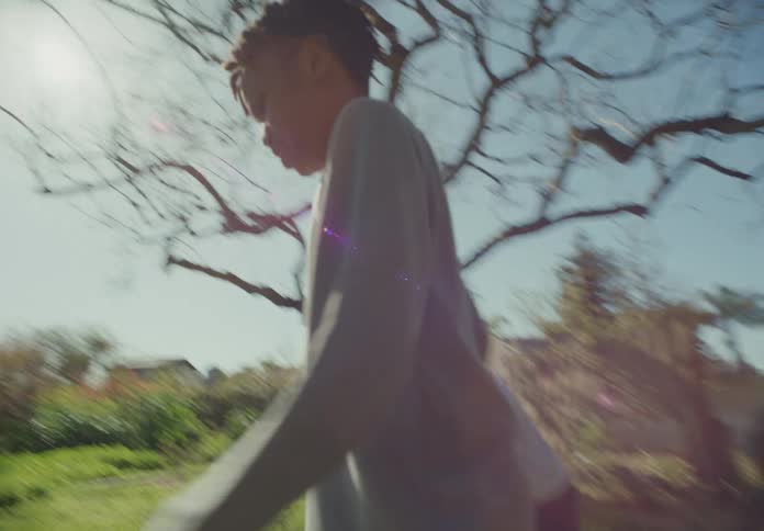 Two boys walk barefoot across a yard