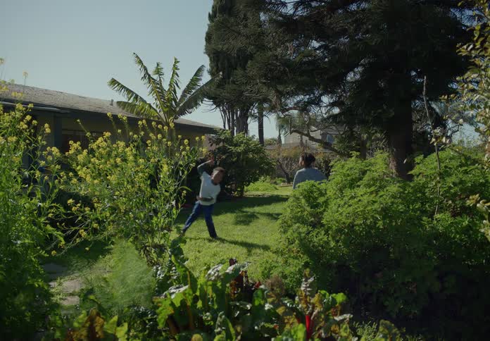 Two children run around the yard