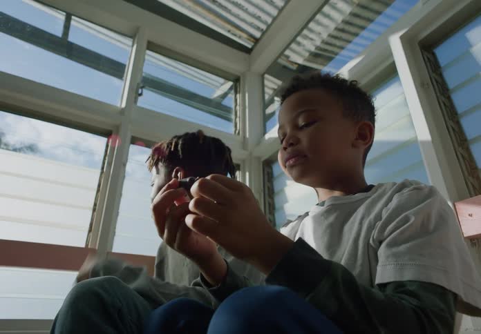 Two tween boys sitting in a sunroom hanging out playing talking