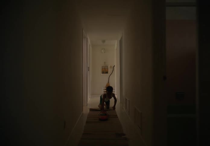 A child pushes his toy car down the hallway