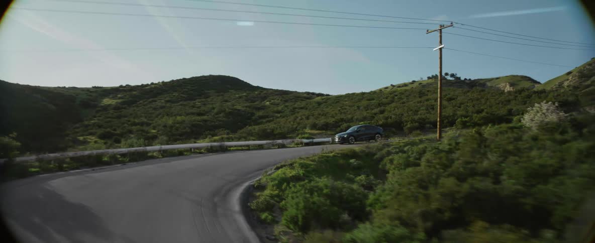 Aerial view of car driving down on winding road