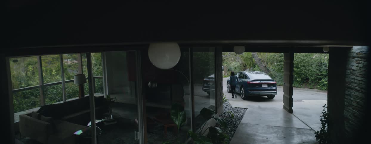 Woman walks through center of house and gets into car