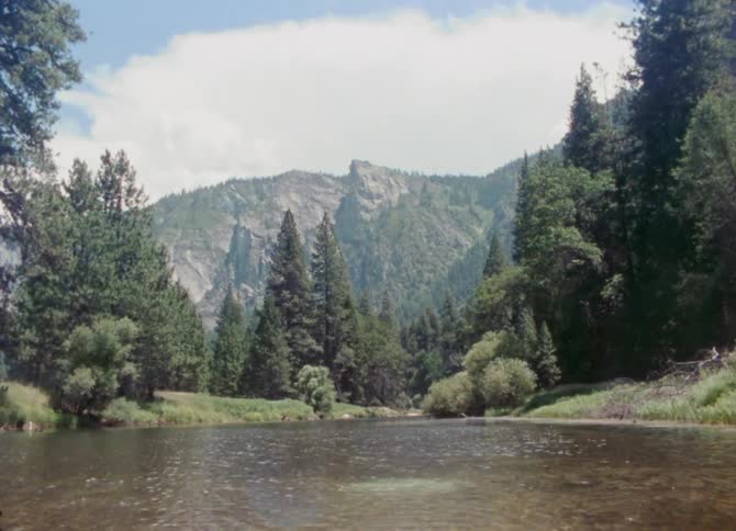 A river flows through a forest below a canyon