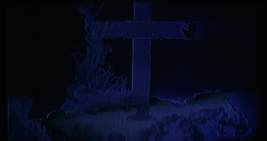 Smoke surrounds a wooden cross planted in the ground