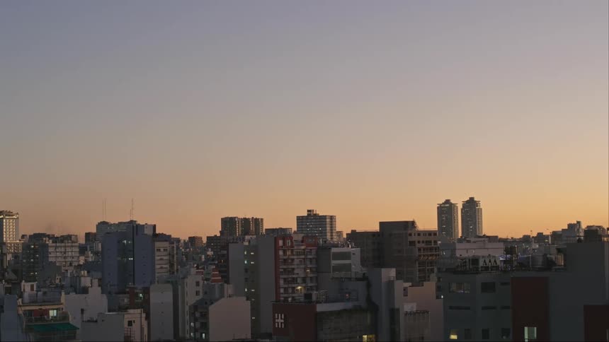 The sun sets over a bustling downtown