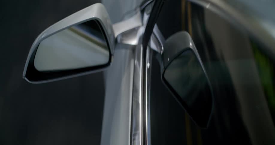 The side mirror on a car as it drives down a street